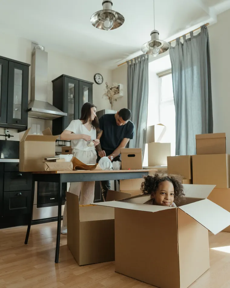 A family unpacking boxes in the kitchen of their new home