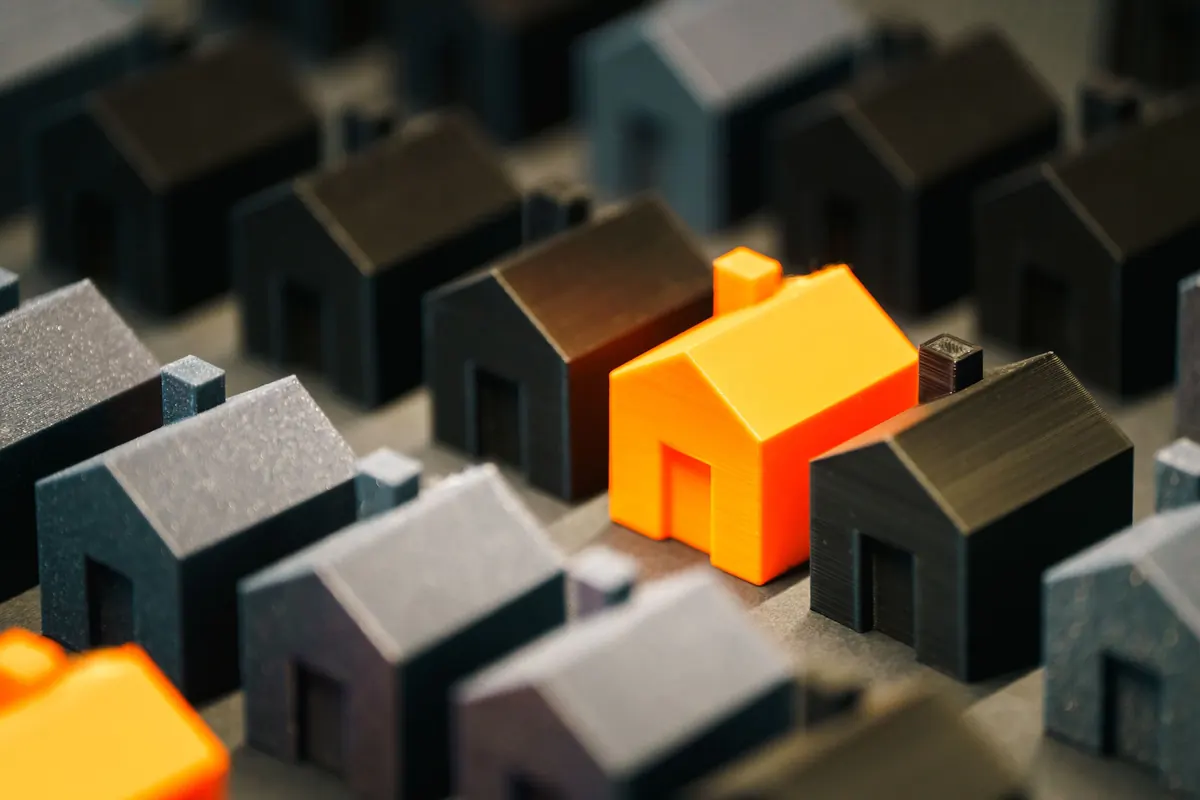 A single orange house standing out among rows of grey houses